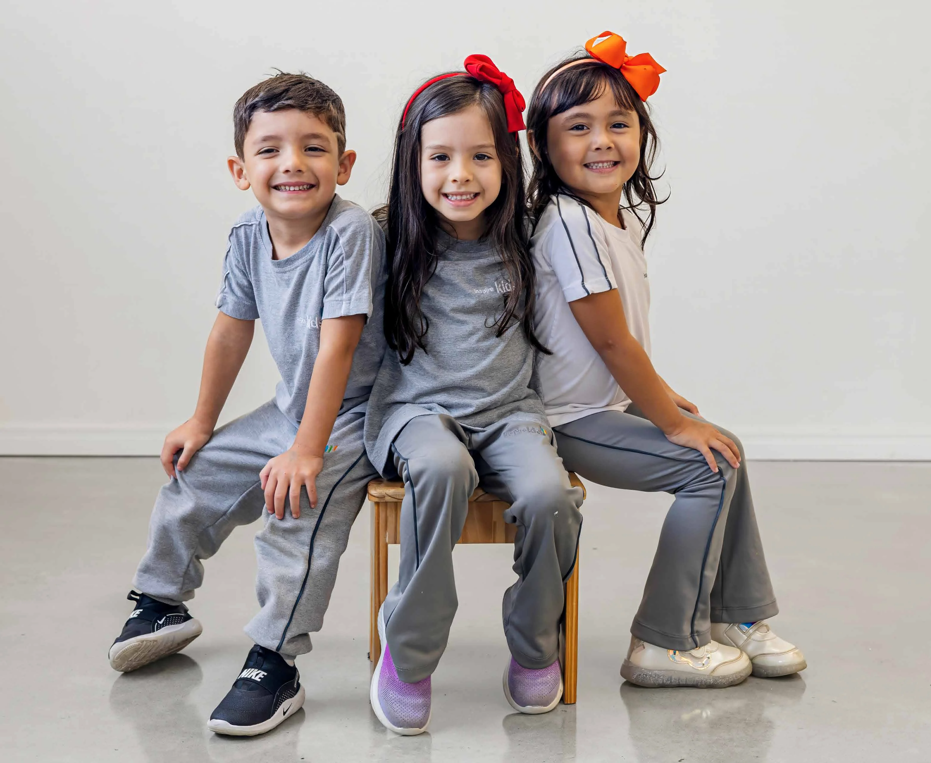 Três alunos do Inspire Kids sorrindo para a câmera