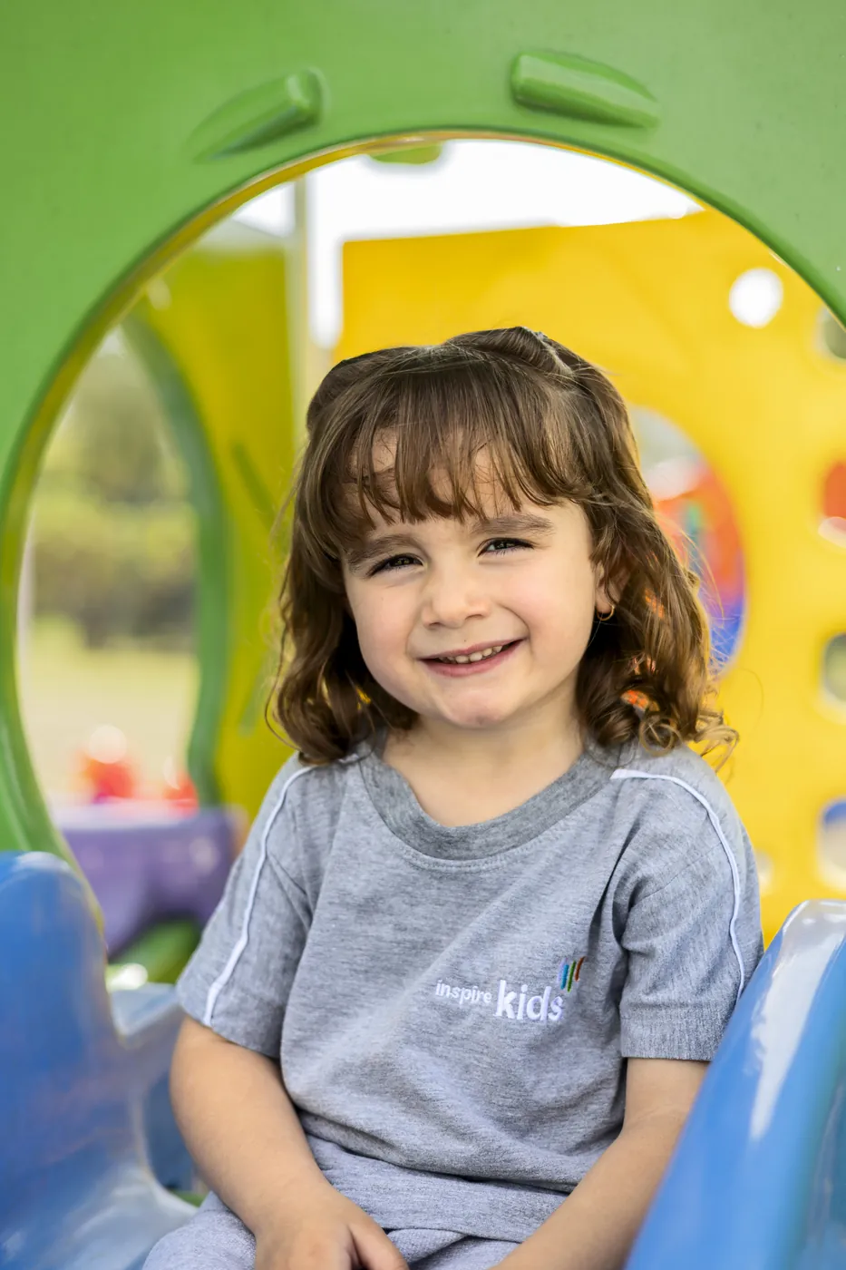 Criança sorrindo no playground do Inspire Kids